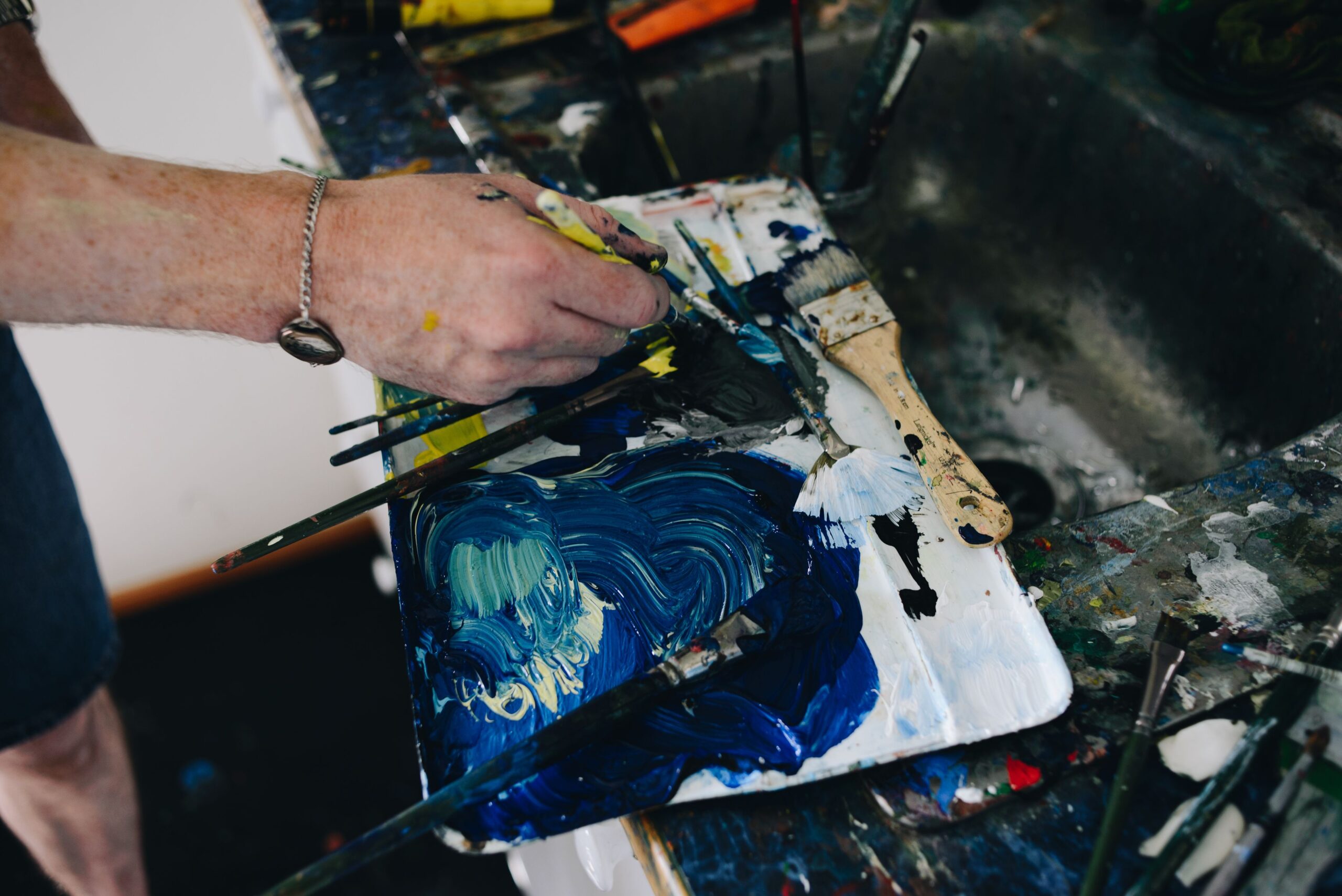 Michael McQuillan mixing paint in his home studio.