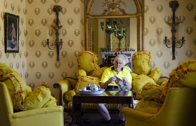 Terry Williams sitting amongst his yellow soft sculptures