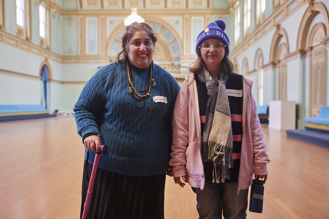 Two people are standing side-by-side smiling at the camera.