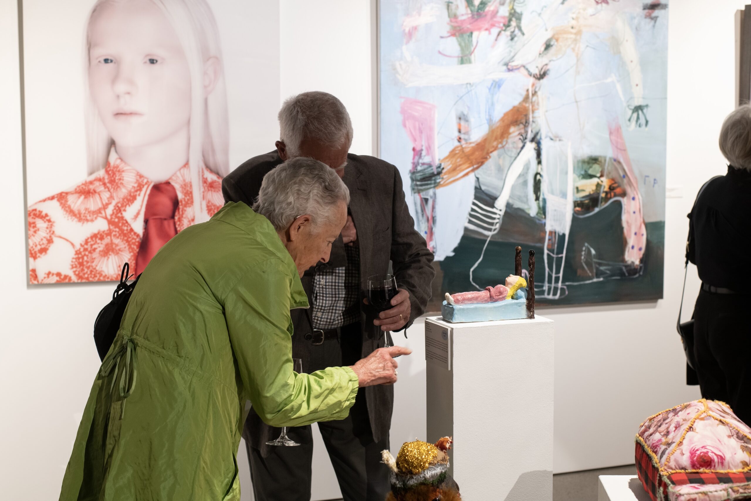 Two people admiring a ceramic sculpture in the leonard joel auction rooms