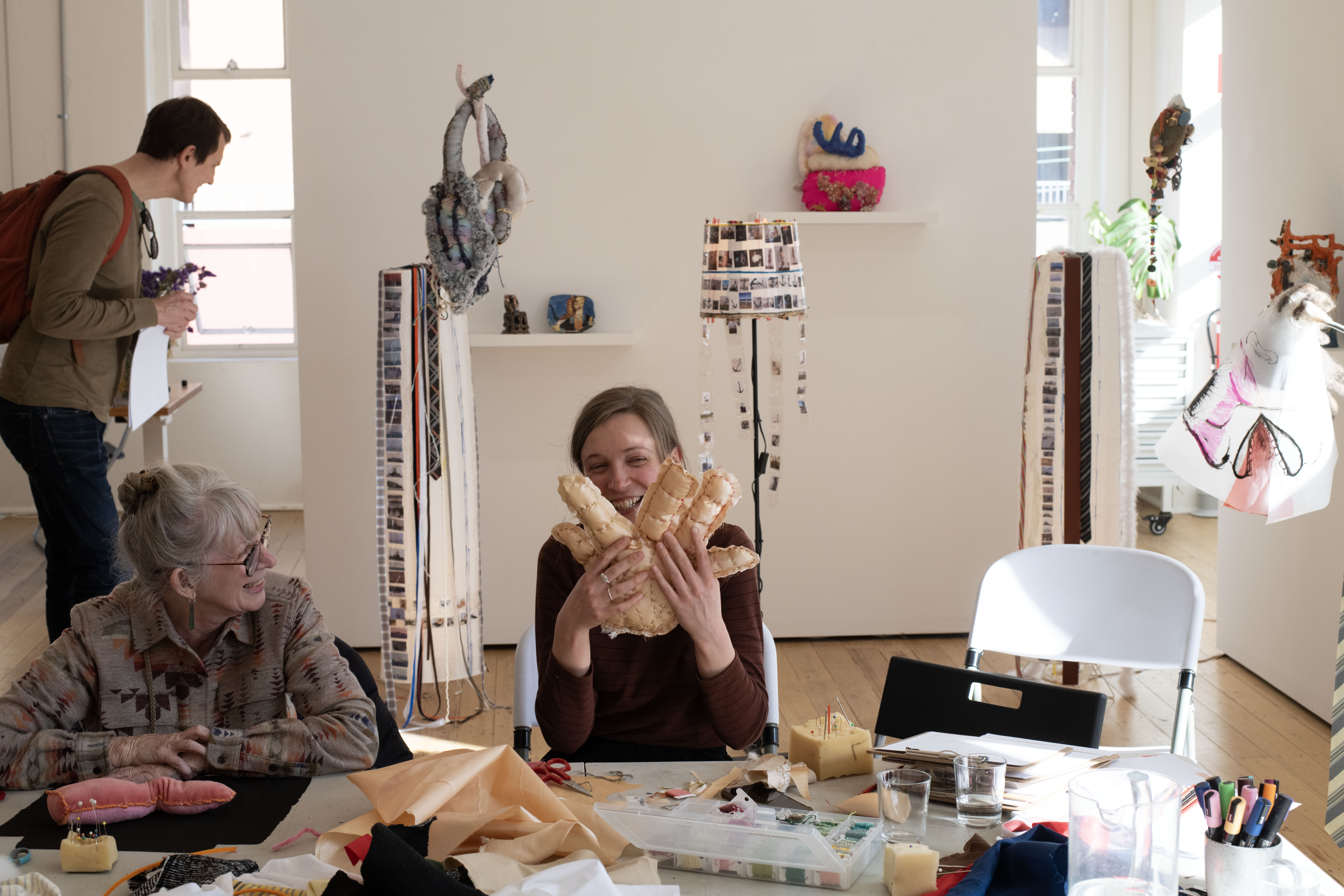 Participant at the Make Your Own Body Parts Workshop holding up their body part: a hand.