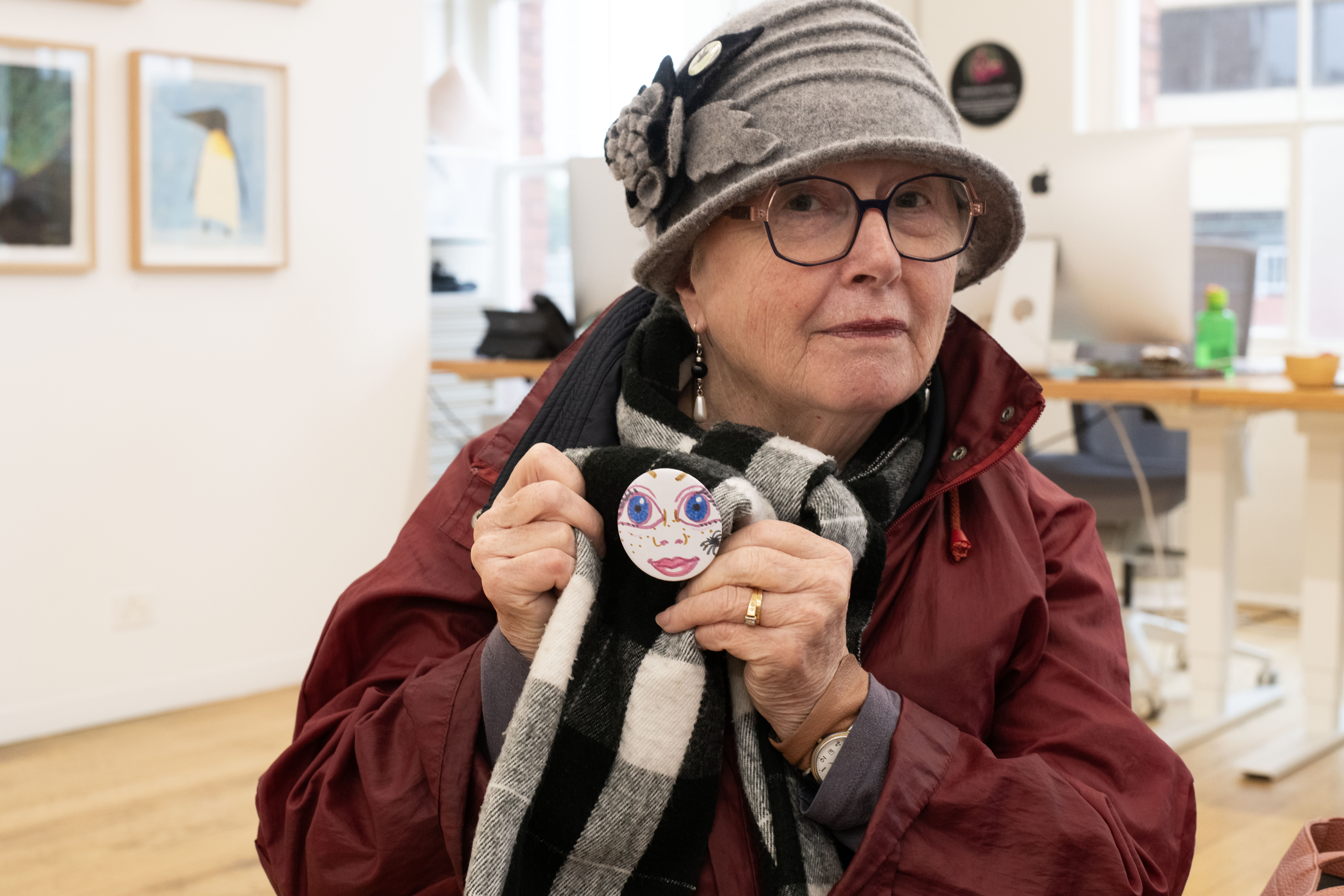 A person holding up the badge they have made at the Strange Creature Creations Workshop