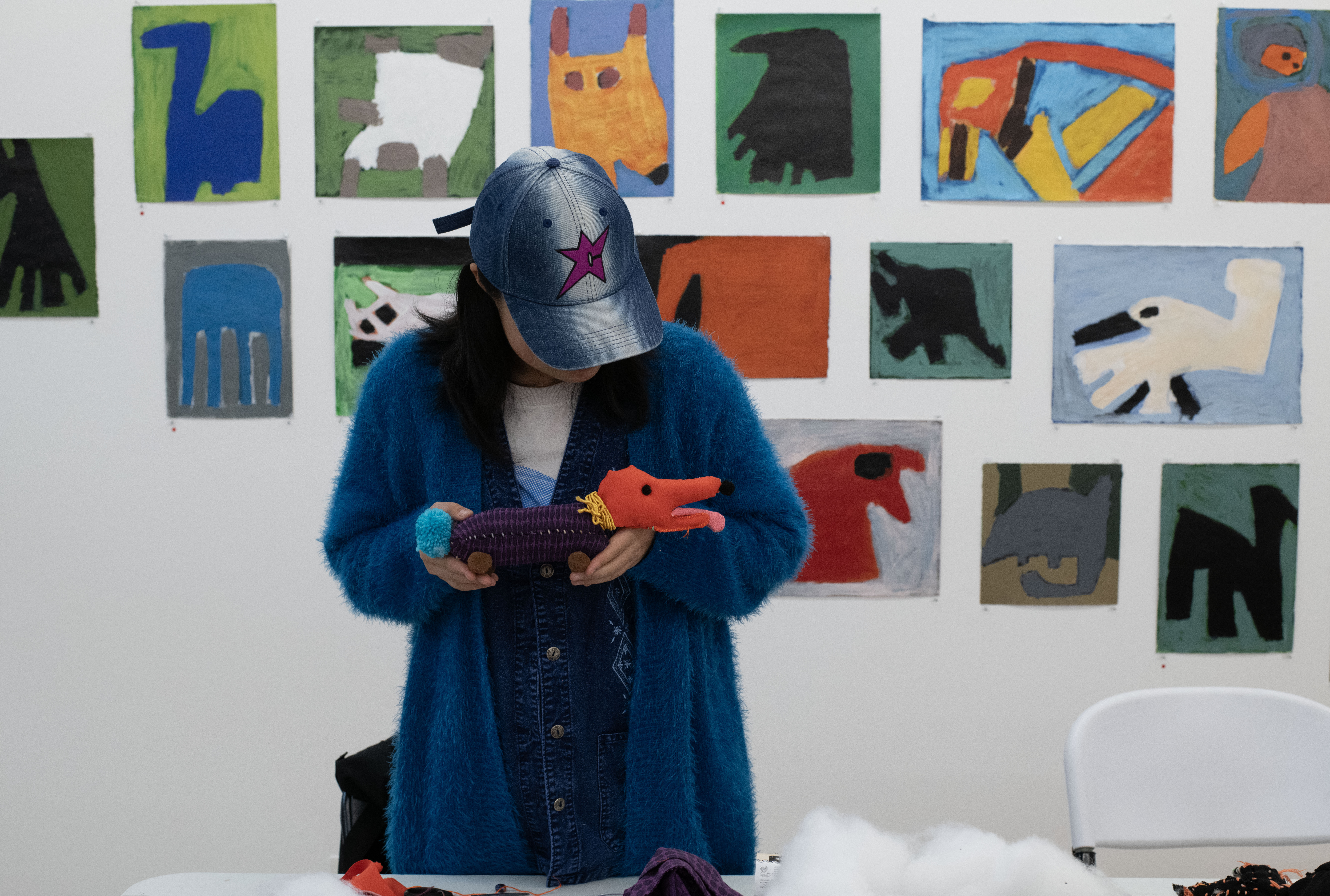 A participant in the Strange Creature Creations Workshop holding up their made creature, a dog.