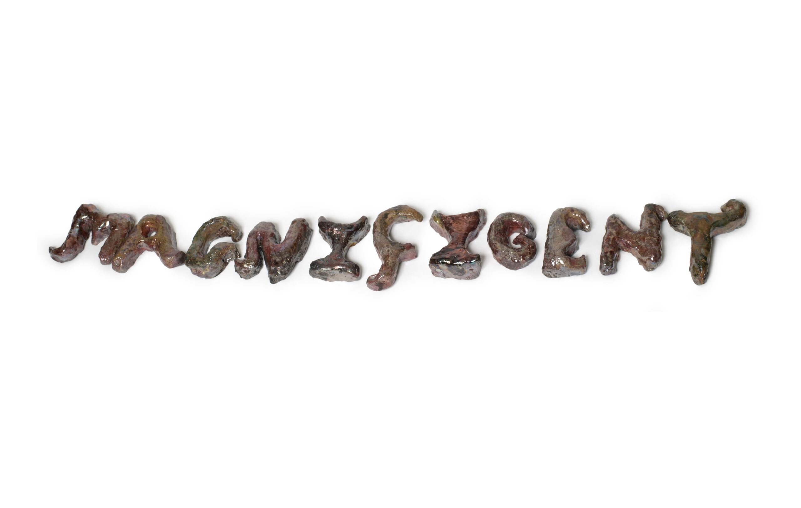 A ceramic work which spells out the word magnificent. It is raku fired giving it a metallic brown and gold finish.