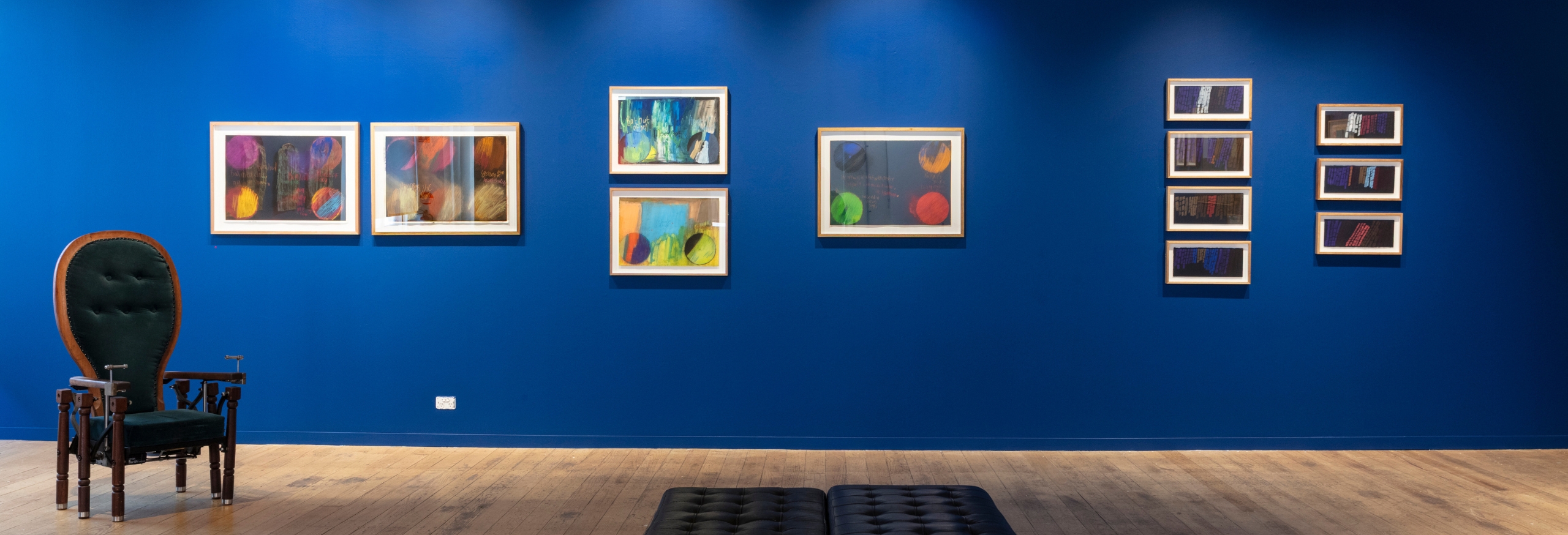 This a photo of the APA gallery. The show on display in the photo is the Stop Work exhibition. The walls have been painted blue and framed artworks are displayed over the top.