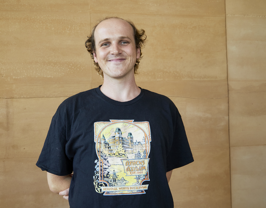 This is a photo of a person smiling into the camera. They are André Shannon, our first guest curator on residence.