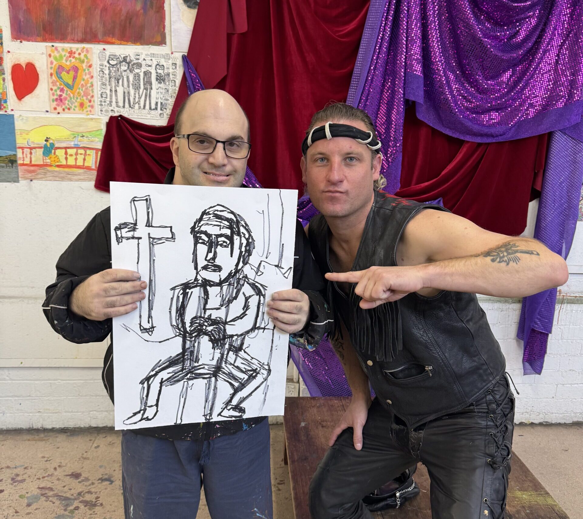 Adrian Lazzaro and Cong Josie posing with Adrian's drawing of Cong Josie in the APA studio.