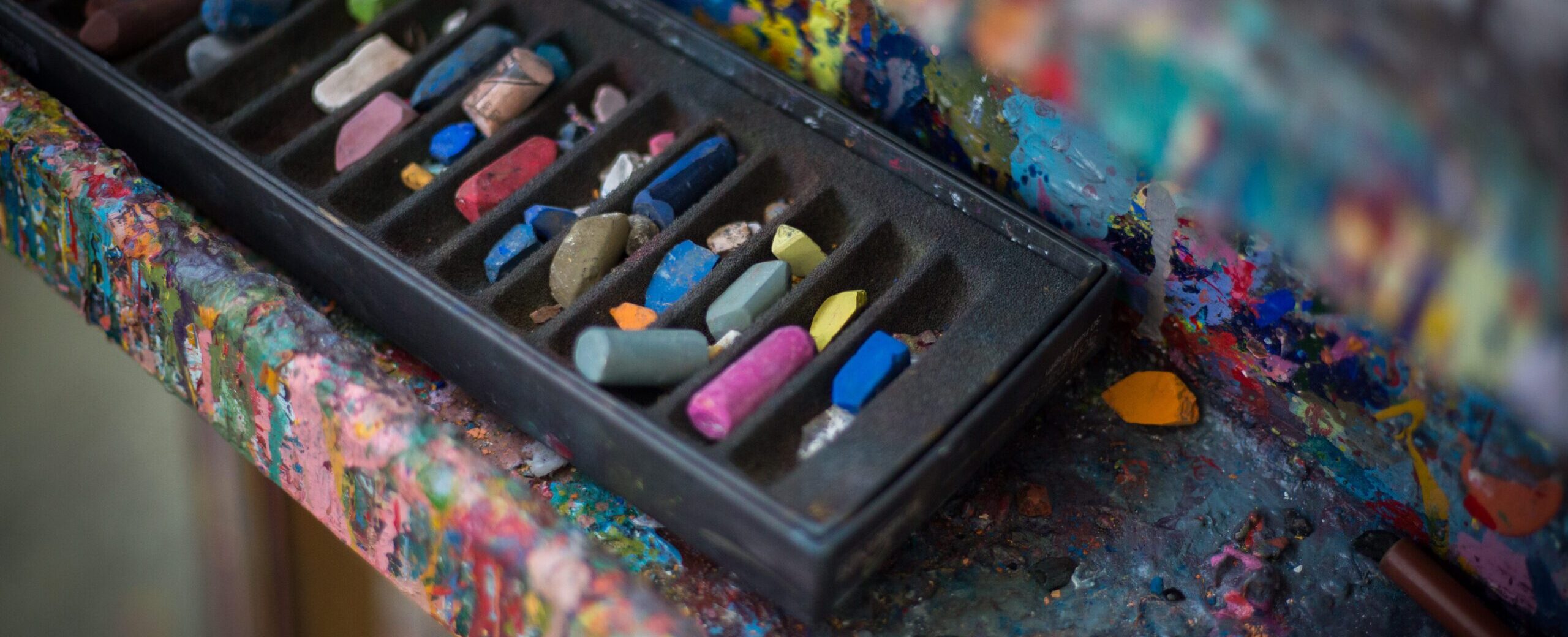Soft pastels on the edge of an easel in the APA studio.